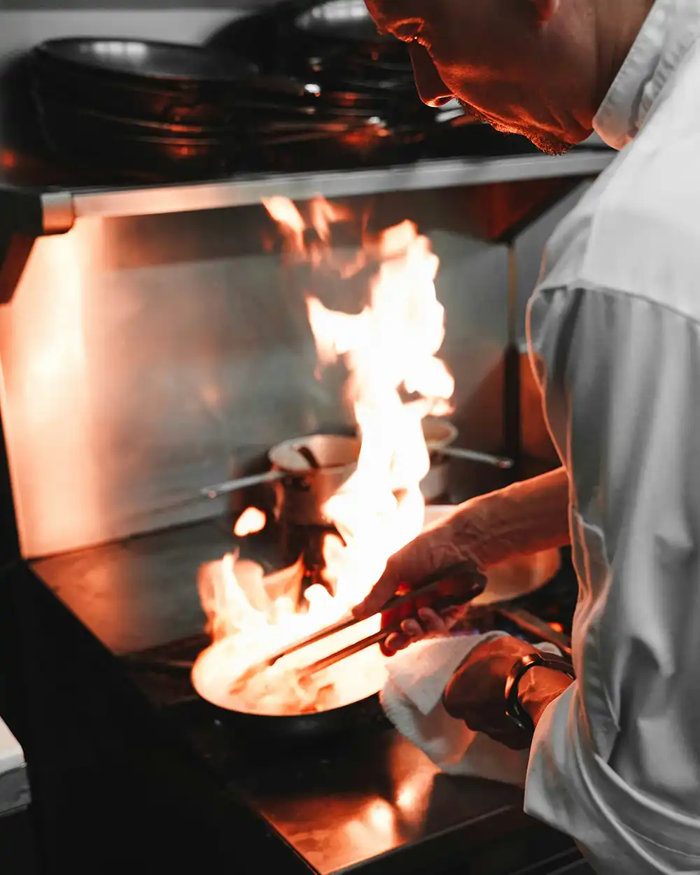 Chef cooking on stove fore flaming up