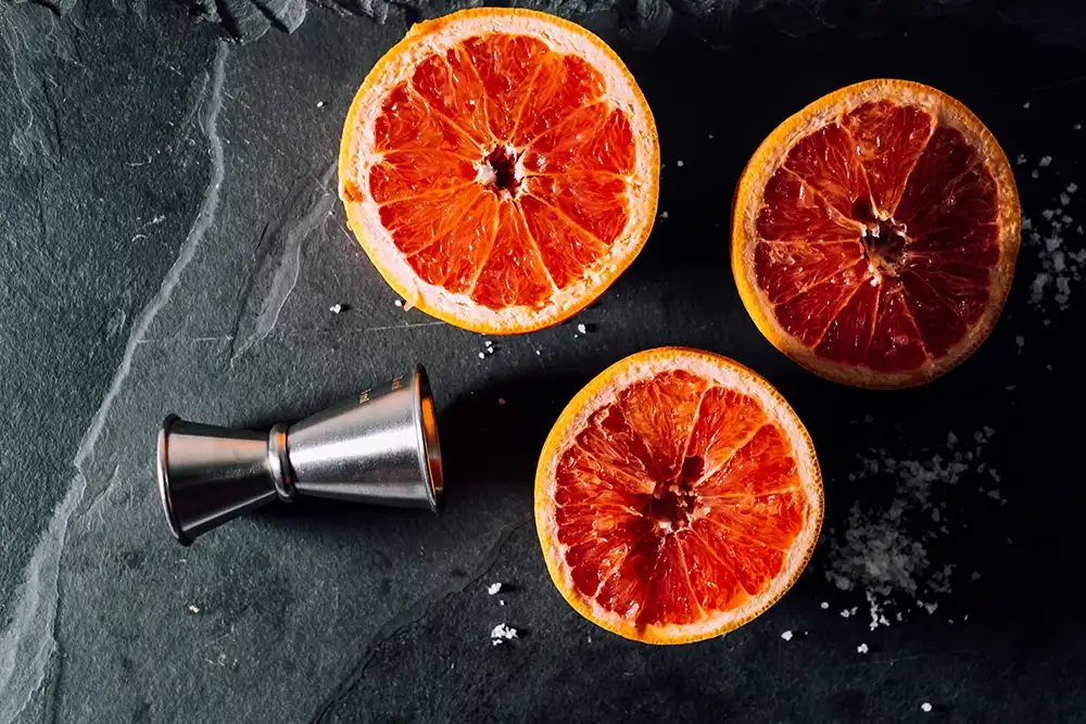 Oranges used for cocktail garnish on a dark background.