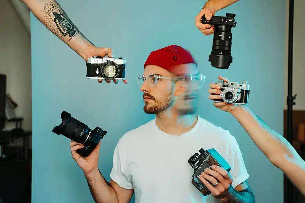 Man with lots of cameras around him